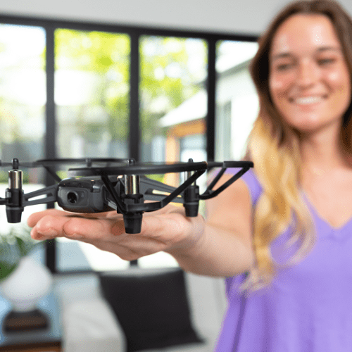 A young woman allows a Trello EDU Drone to gently land in the palm of her hand